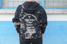 Load image into Gallery viewer, A model is shown wearing the sweatshirt with black sweatpants in front of a blue wall from the back.